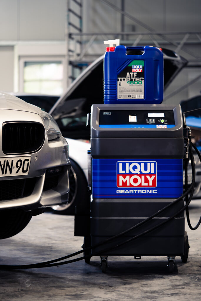 Getriebeölservice mit LIQUI MOLY Geartronic neben einem BMW in der Werkstatt